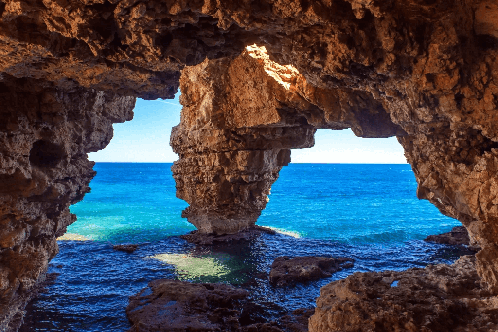 Natural sea cave with crystal clear Mediterranean water in Costa Blanca